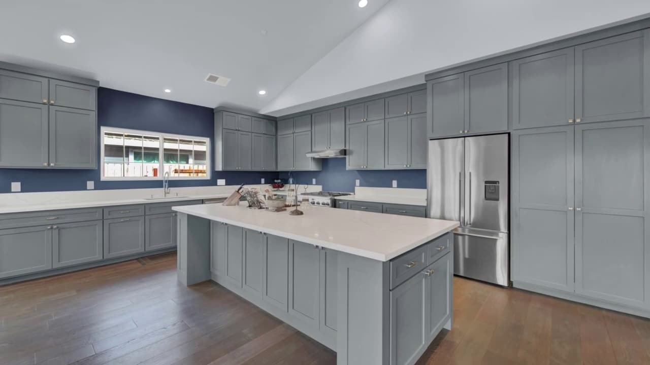 Open floor plan kitchen with gray cabinets and stainless appliances in Sacramento — Keystone Building Services