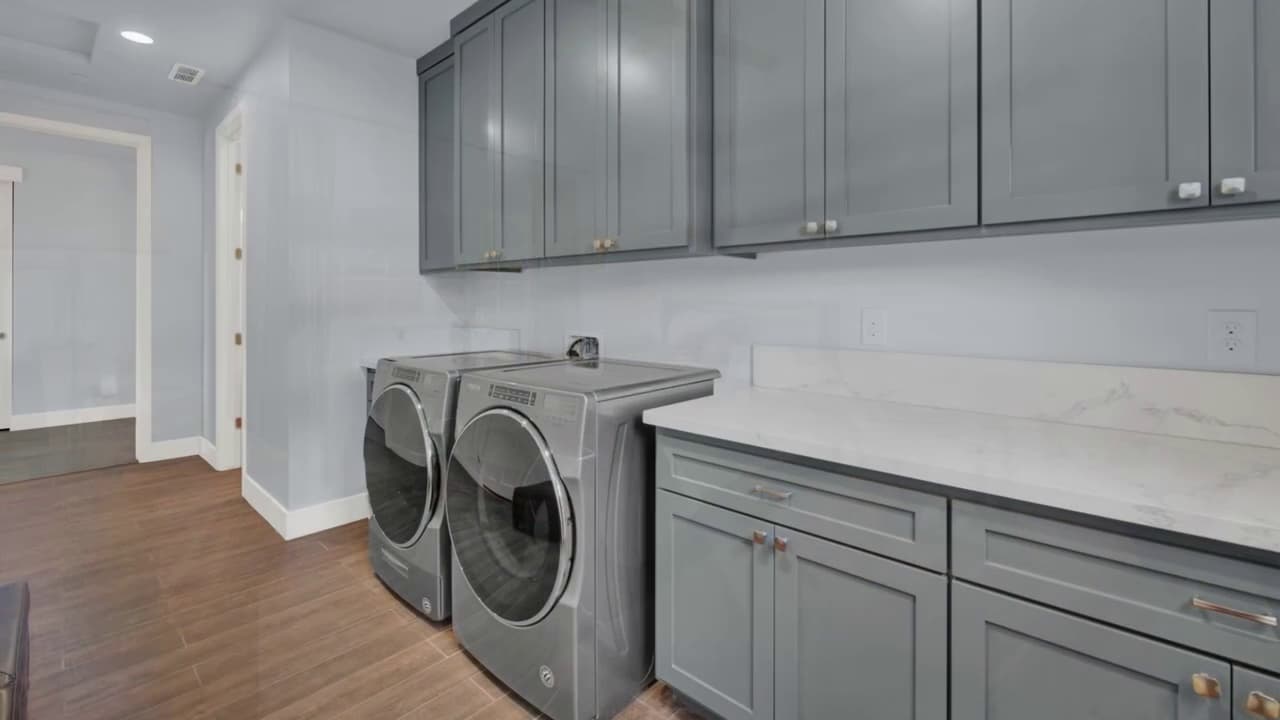 Custom laundry room with gray cabinets and marble countertop in Sacramento — Keystone Building Services